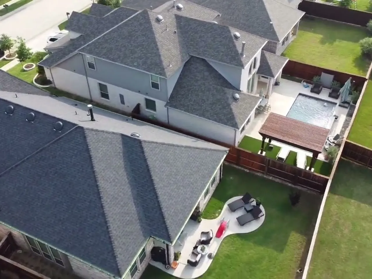 Aerial view of a completed black shingle roof replacement in Lantana, TX